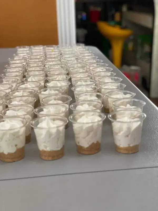 Rows of cheesecake shooters in small clear cups