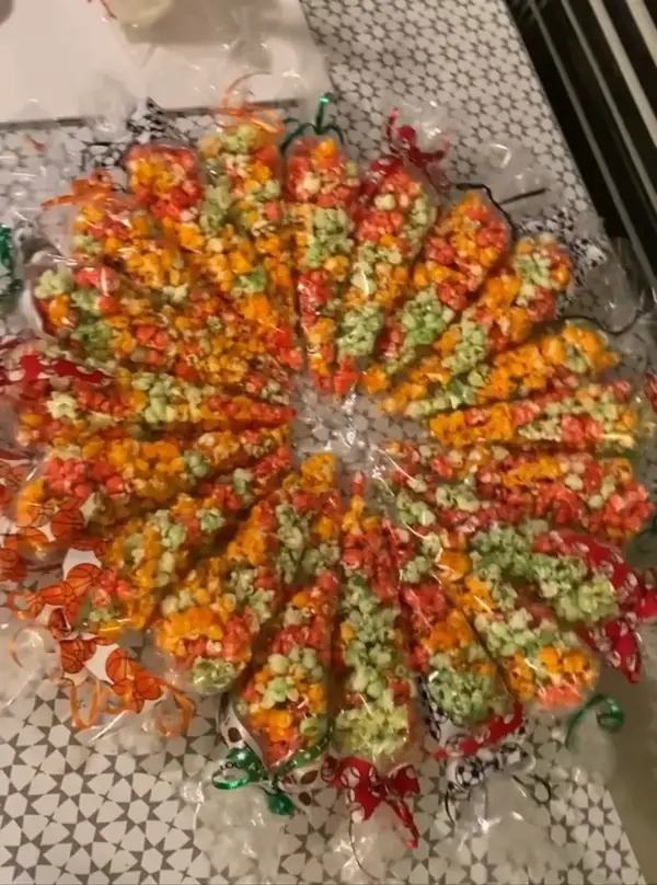 Bags of orange candied popcorn tied with ribbon for a party